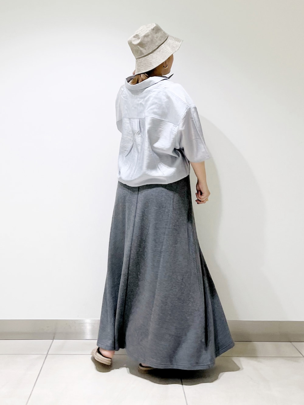 ブルー系のシャツ/ブラウス、グレー系のスカート、ベージュ系のサンダルを着用したレディースの春コーディネートの2枚目の写真