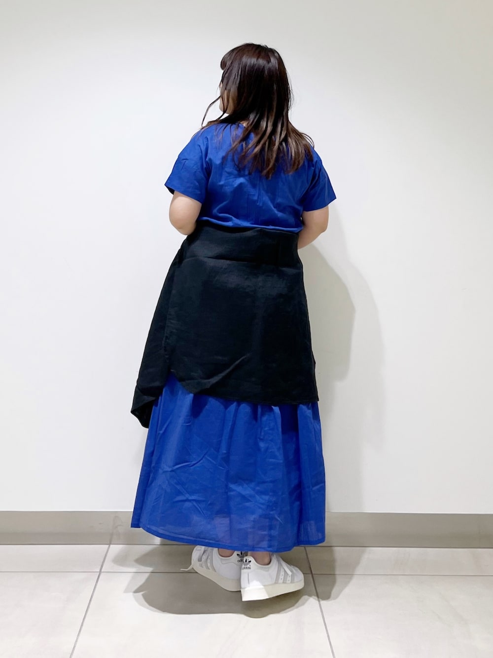 ブルー系のワンピース、ブラック系のシャツ/ブラウス、ホワイト系のスニーカーを着用したレディースの春コーディネートの3枚目の写真