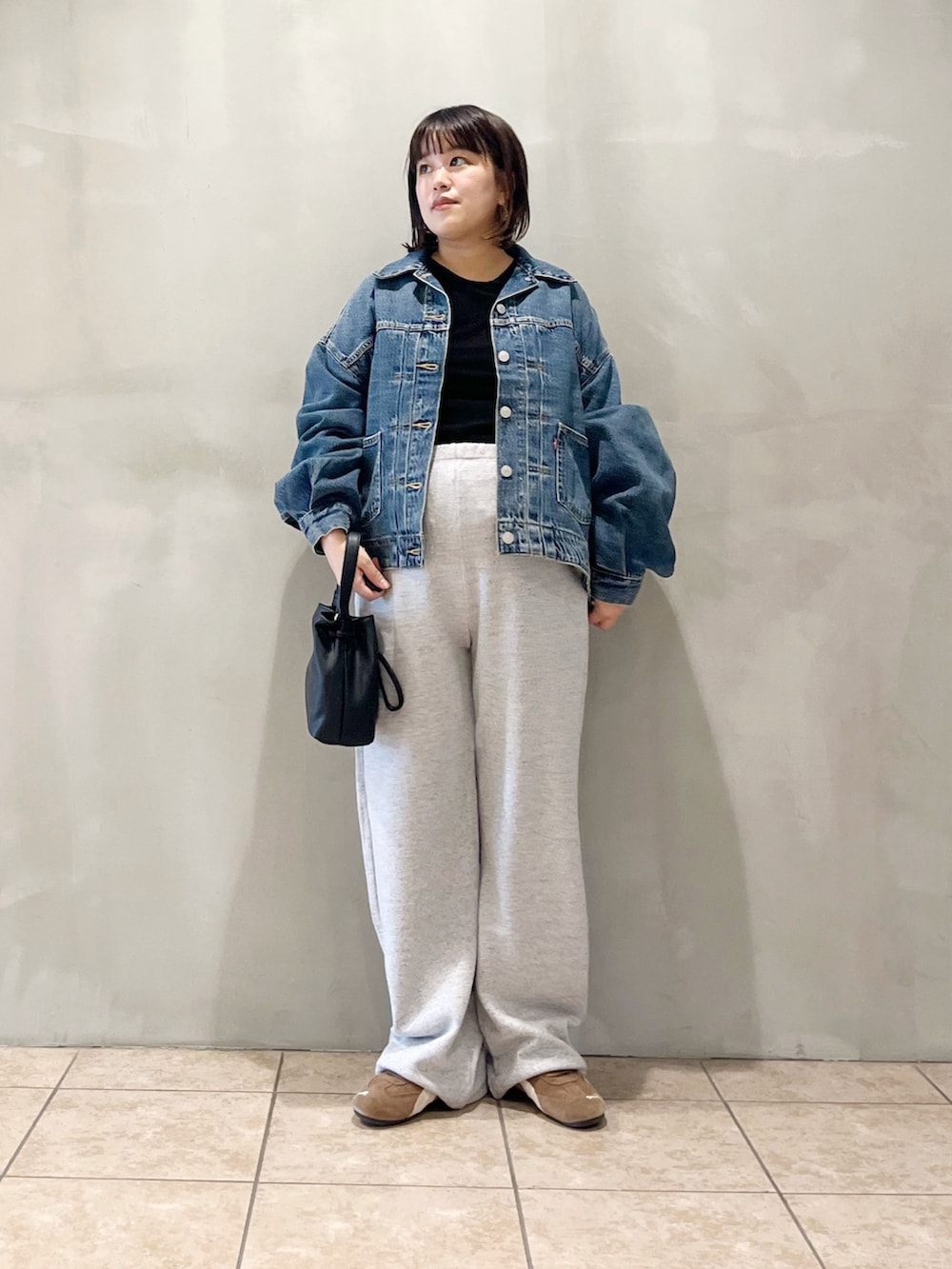 ブルー系のデニムジャケット、ブラック系のスニーカー、グレー系のその他パンツを着用したレディースの秋コーディネートの8枚目の写真