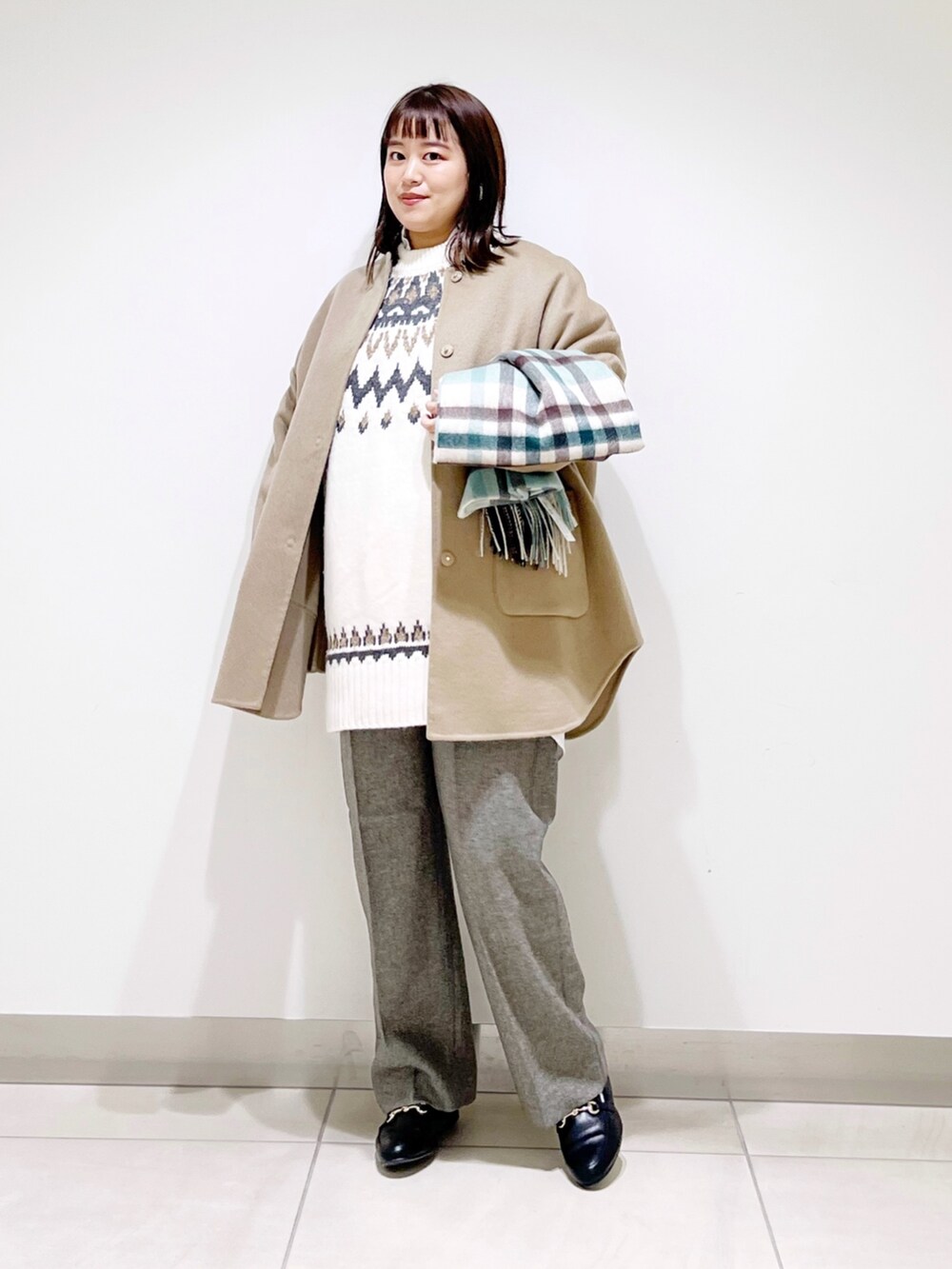 ベージュ系のノーカラージャケット、ホワイト系のニット/セーター、グレー系のその他パンツを着用したレディースの秋コーディネートの9枚目の写真