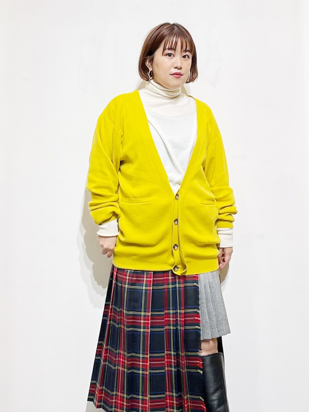 イエロー系のカーディガン/ボレロ、ホワイト系のニット/セーター、その他のスカートを着用したレディースの冬コーディネートの4枚目の写真
