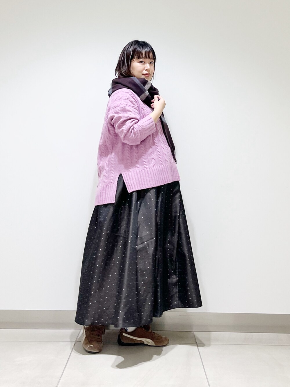 パープル系のニット/セーター、ブルー系のスカート、ブラック系のスニーカーを着用したレディースの秋コーディネートの6枚目の写真