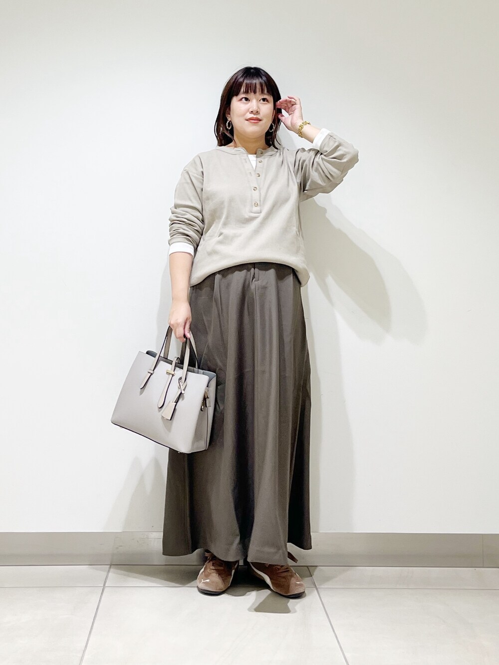 ベージュ系のTシャツ/カットソー、ブラウン系のスカート、グレー系のトートバッグを着用したレディースの秋コーディネートの9枚目の写真