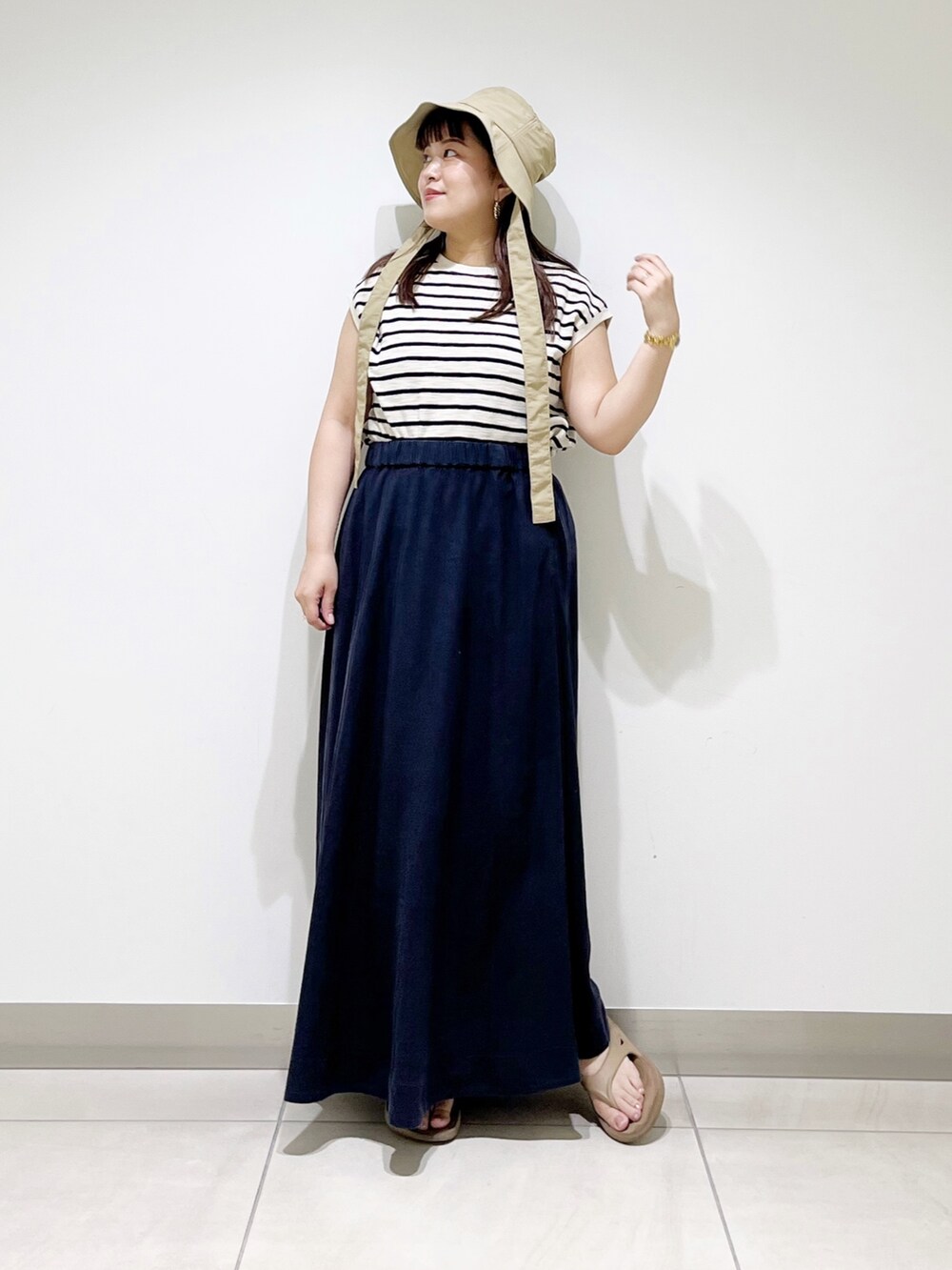 ベージュ系のTシャツ/カットソー、ブルー系のスカート、ベージュ系のサンダルを着用したレディースの夏コーディネートの2枚目の写真