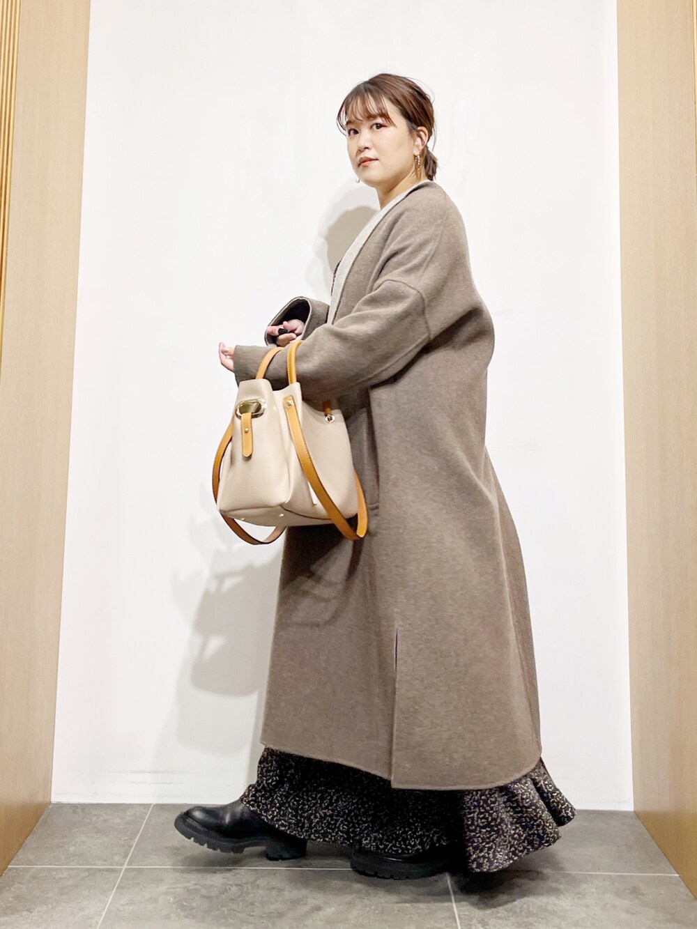 グレー系のその他アウター、ブラック系のワンピース、ベージュ系のトートバッグを着用したレディースの秋コーディネートの3枚目の写真