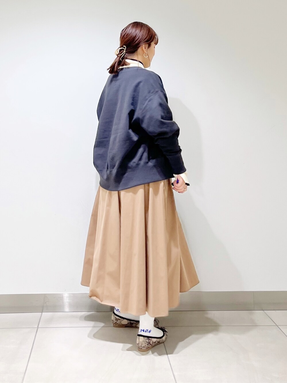 グリーン系のトートバッグ、ベージュ系のスカート、その他のバレエシューズを着用したレディースの秋コーディネートの6枚目の写真