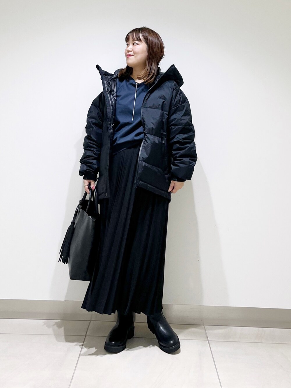 ブラック系のダウンジャケット/コート、ブルー系のTシャツ/カットソー、ブラック系のスカートを着用したレディースの秋コーディネートの10枚目の写真