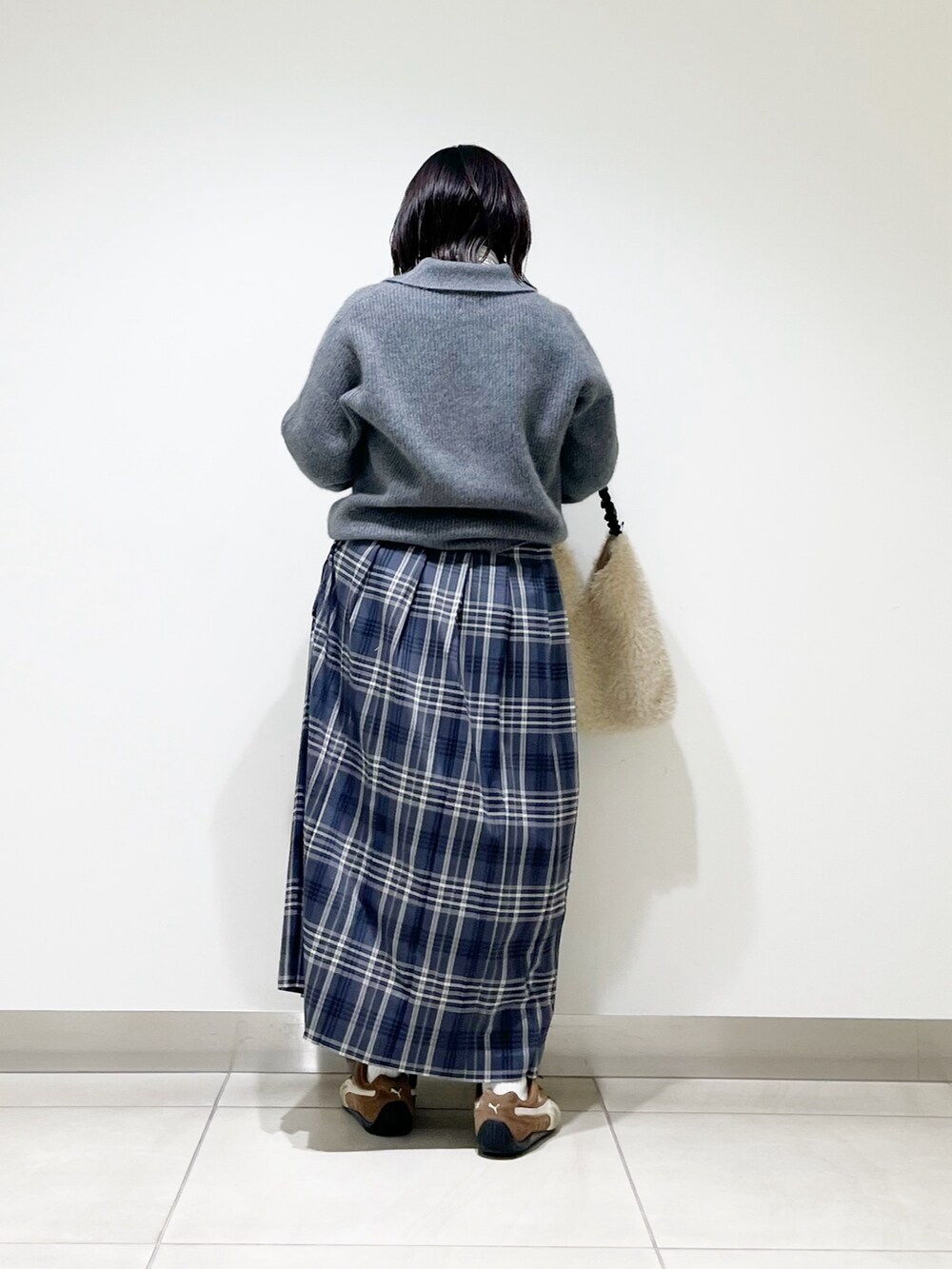グレー系のニット/セーター、ホワイト系のTシャツ/カットソー、ホワイト系のバッグを着用したレディースの秋コーディネートの6枚目の写真