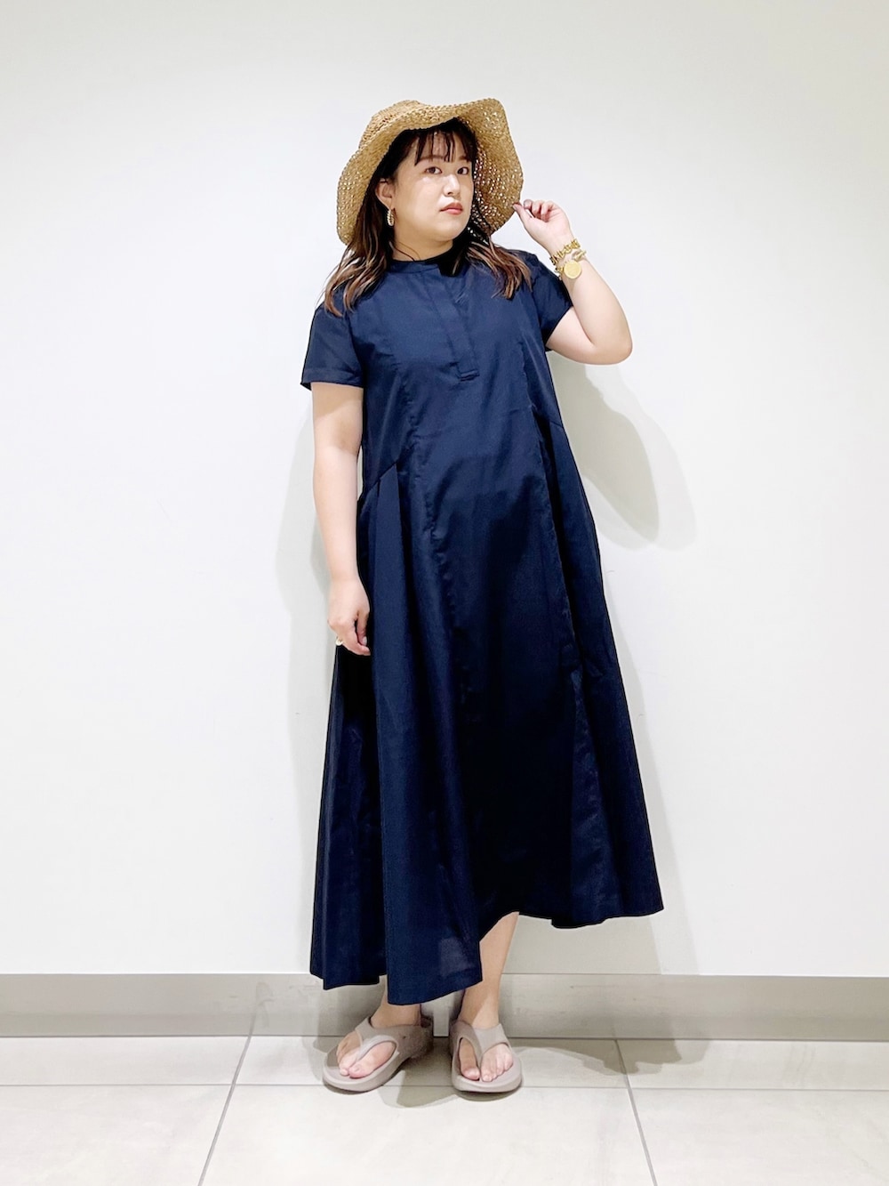 ブルー系のワンピース、ベージュ系のサンダル、ベージュ系のハットを着用したレディースの春コーディネートの3枚目の写真