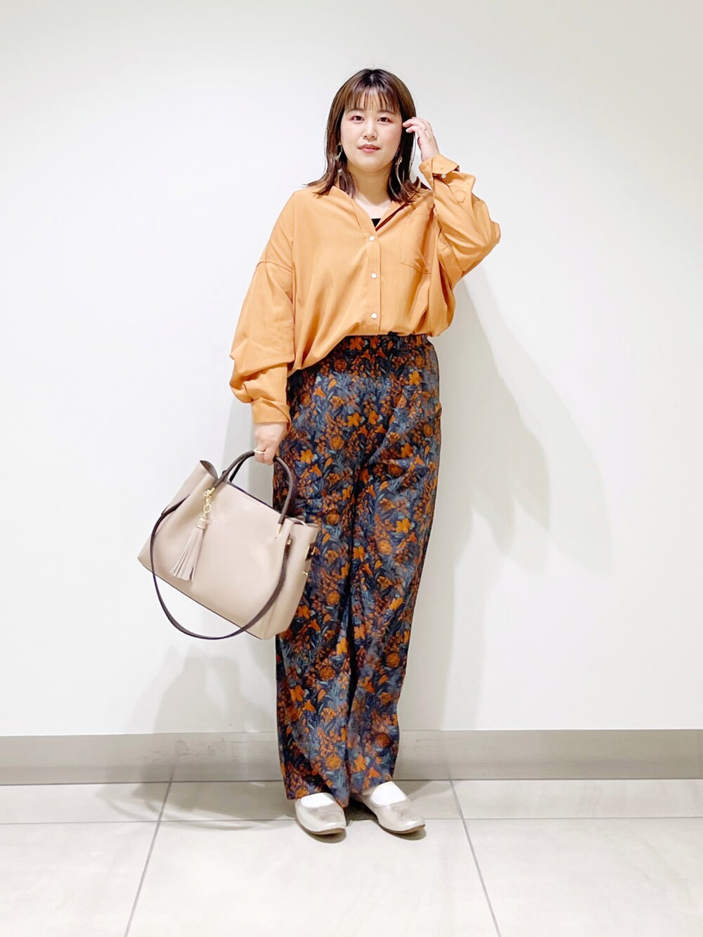オレンジ系のシャツ/ブラウス、ベージュ系のトートバッグ、ゴールド系のその他シューズを着用したレディースの夏コーディネートの5枚目の写真