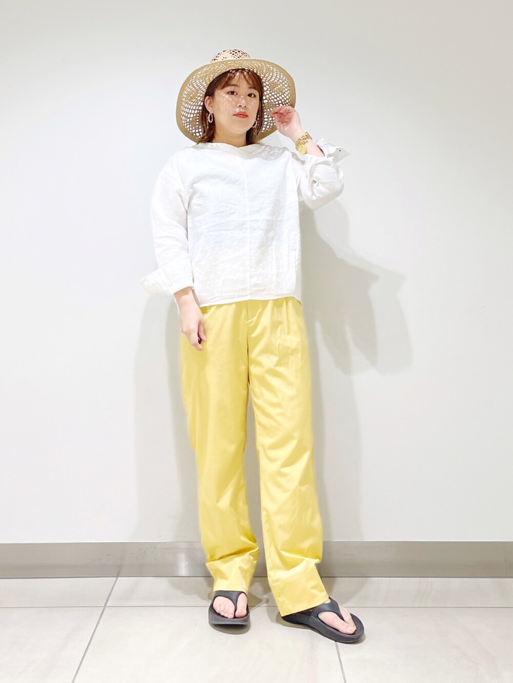 ホワイト系のシャツ/ブラウス、イエロー系のその他パンツ、ブラック系のサンダルを着用したレディースの春コーディネートの3枚目の写真