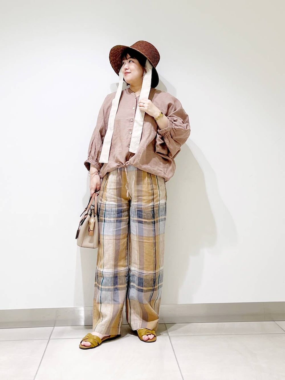 ベージュ系のハンドバッグ、イエロー系のその他パンツ、イエロー系のサンダルを着用したレディースの春コーディネートの8枚目の写真