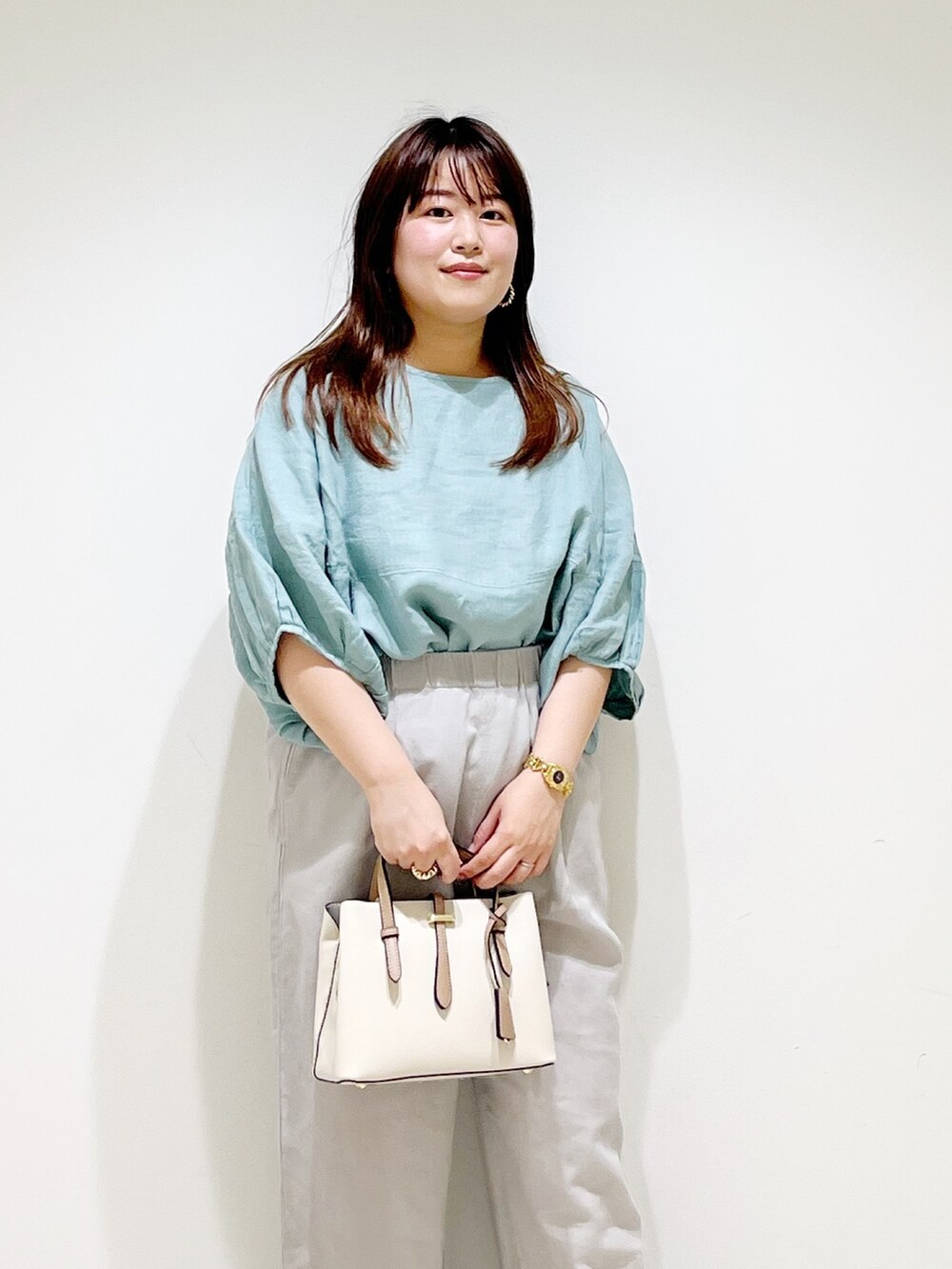 グリーン系のシャツ/ブラウス、ベージュ系のその他パンツ、ホワイト系のトートバッグを着用したレディースの夏コーディネートの4枚目の写真