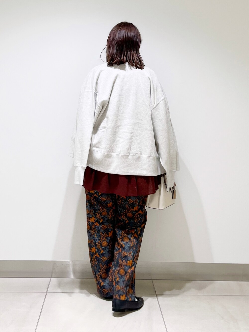 オレンジ系のその他パンツ、レッド系のシャツ/ブラウス、グレー系のカーディガン/ボレロを着用したレディースの秋コーディネートの4枚目の写真