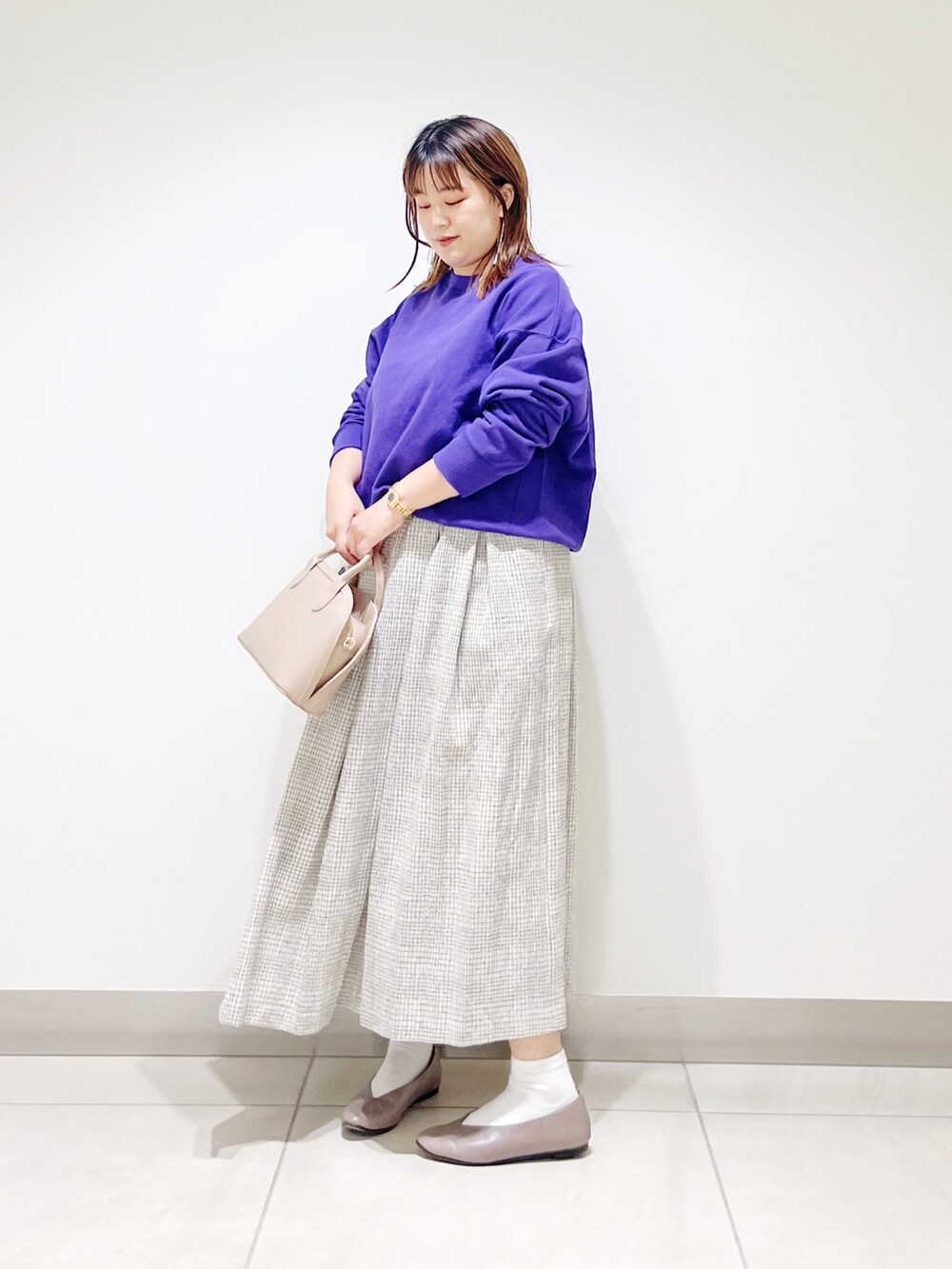 パープル系のスウェット、ホワイト系のスカート、ベージュ系のショルダーバッグを着用したレディースの秋コーディネートの4枚目の写真