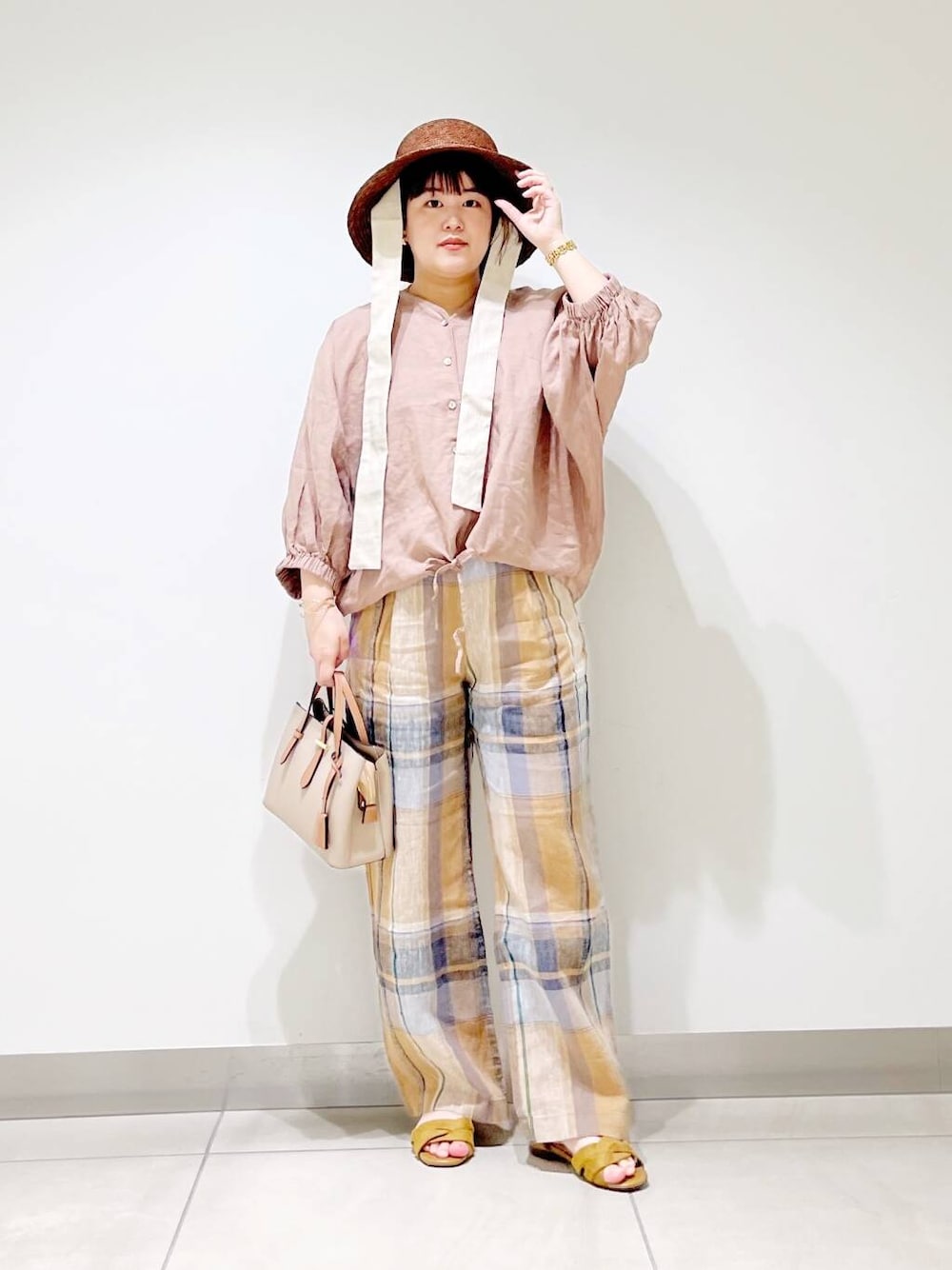 ベージュ系のハンドバッグ、イエロー系のその他パンツ、イエロー系のサンダルを着用したレディースの春コーディネートの9枚目の写真