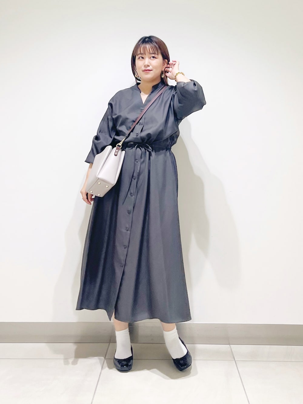 グレー系のワンピース、グレー系のショルダーバッグ、ブラック系のバレエシューズを着用したレディースの秋コーディネートの4枚目の写真