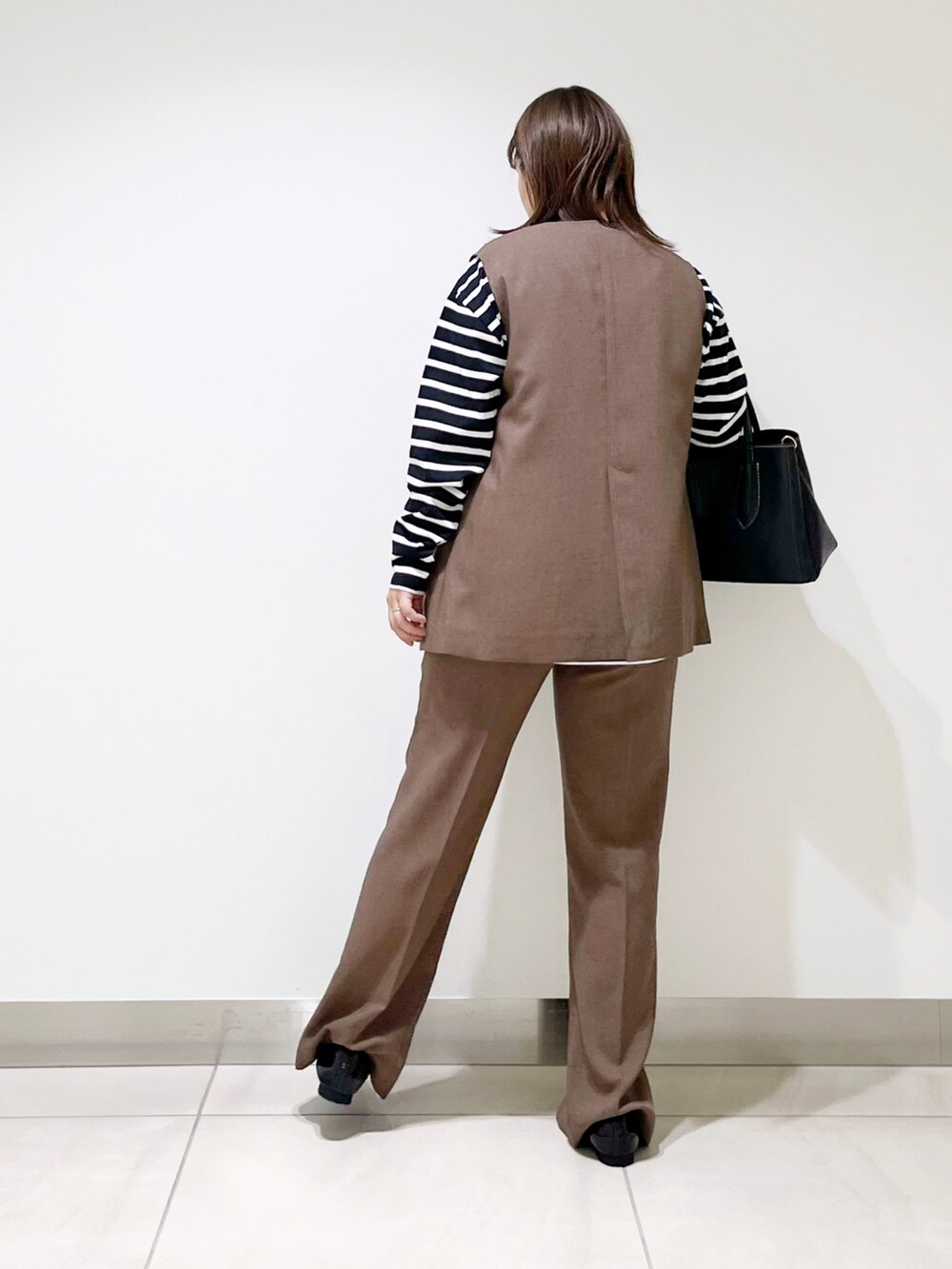 ブラウン系のベスト、ブラウン系のその他パンツ、ブラック系のTシャツ/カットソーを着用したレディースの夏コーディネートの4枚目の写真
