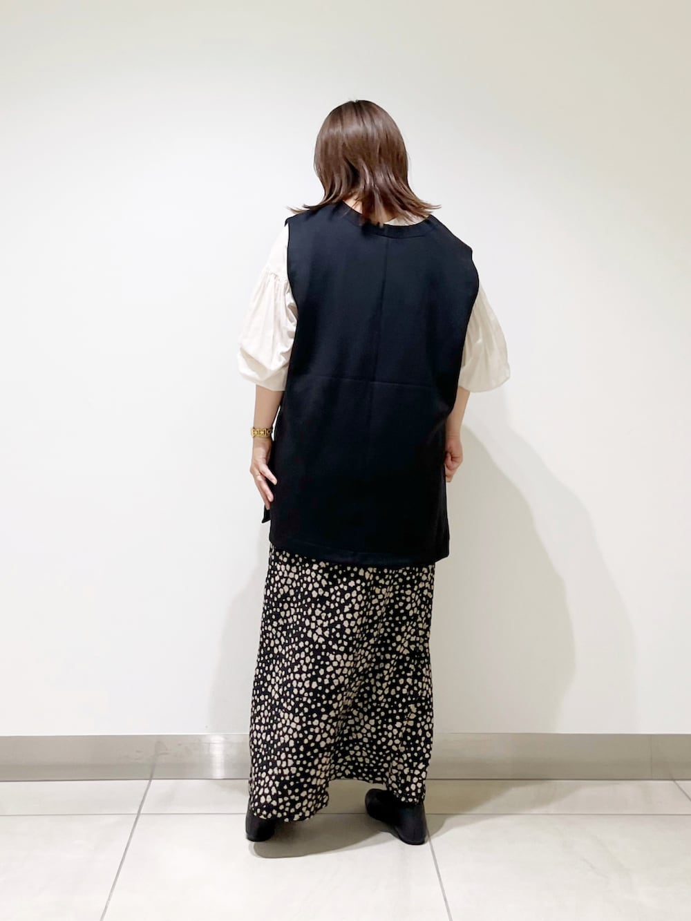 ブラック系のベスト、ホワイト系のシャツ/ブラウス、ブラック系のスカートを着用したレディースの夏コーディネートの4枚目の写真