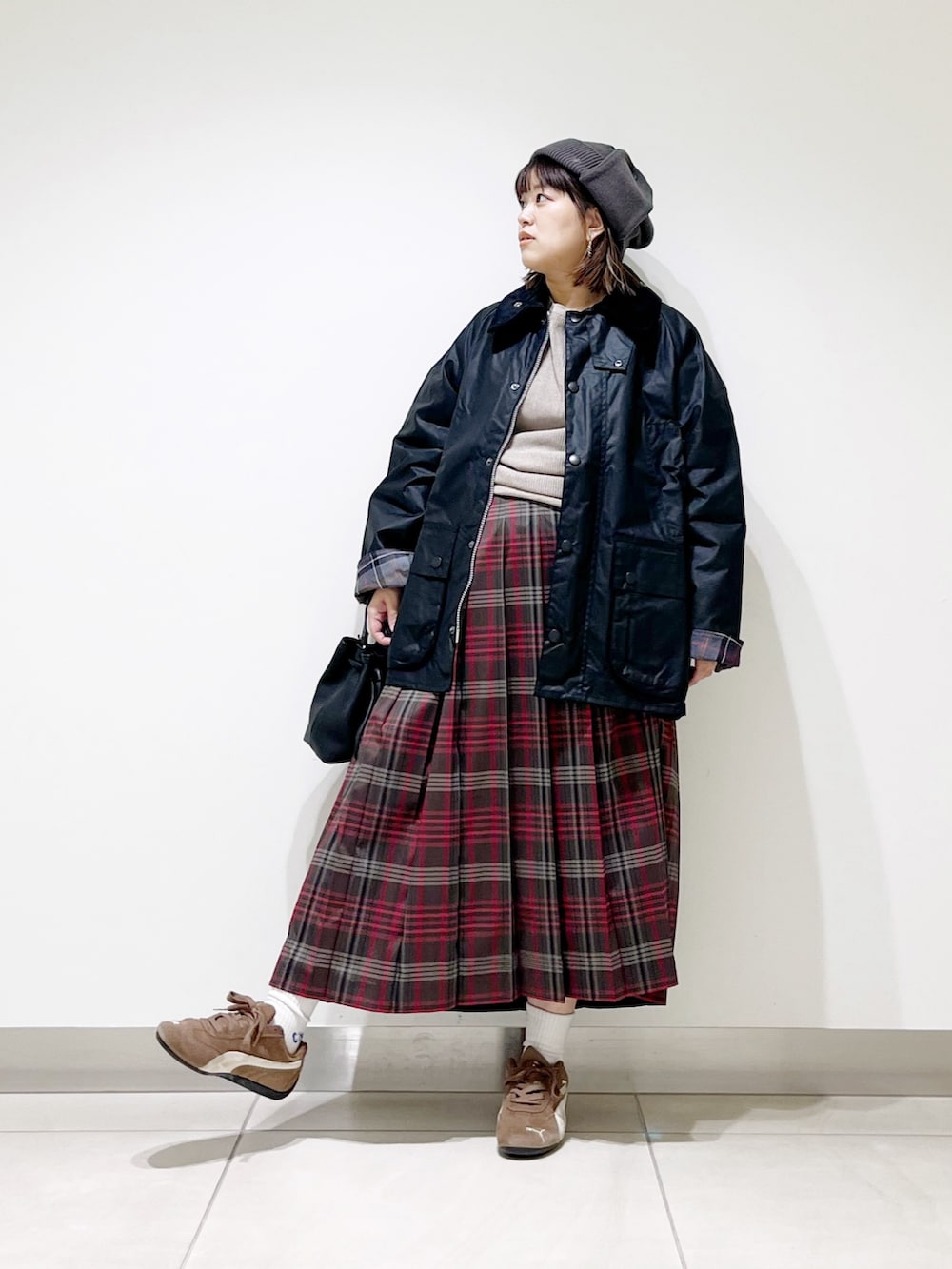 ブラック系のテーラードジャケット、グレー系のTシャツ/カットソー、ブラウン系のスカートを着用したレディースの秋コーディネートの2枚目の写真