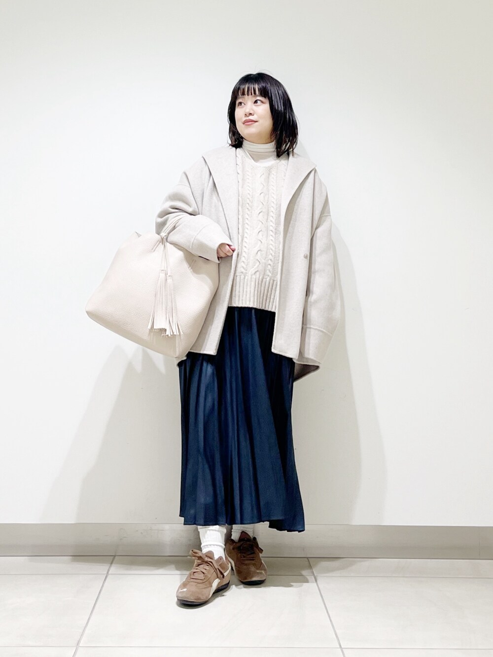 ベージュ系のその他アウター、ベージュ系のニット/セーター、ホワイト系のトートバッグを着用したレディースの秋コーディネートの6枚目の写真