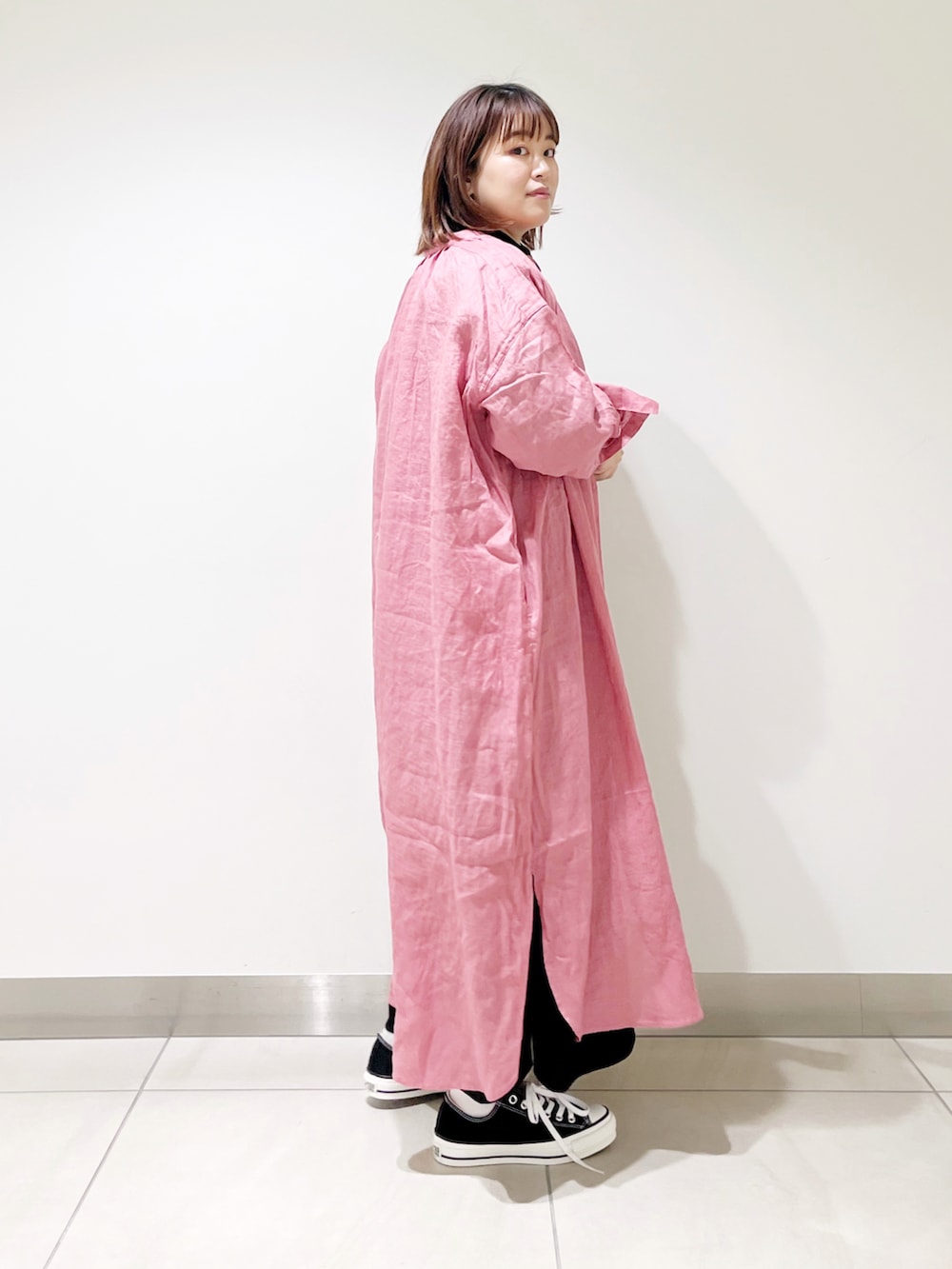 ブラック系のワンピース、ピンク系のワンピース、ブラック系のスニーカーを着用したレディースの春コーディネートの2枚目の写真