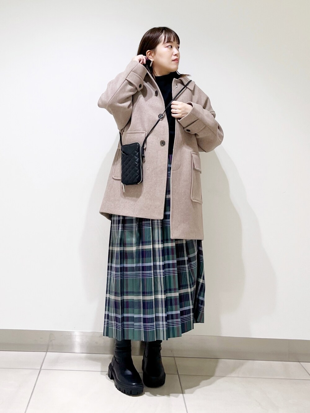 ブラウン系のその他アウター、ブラック系のニット/セーター、グリーン系のスカートを着用したレディースの秋コーディネートの6枚目の写真