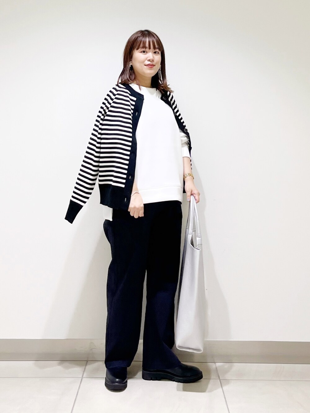 ホワイト系のTシャツ/カットソー、ブラック系のカーディガン/ボレロ、ブルー系のその他パンツを着用したレディースの秋コーディネートの7枚目の写真