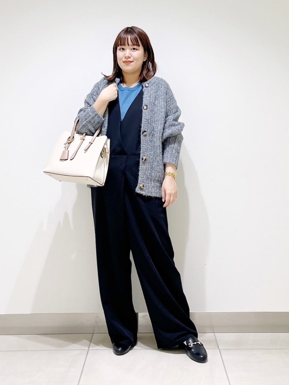 ブルー系のニット/セーター、グレー系のカーディガン/ボレロ、ブラック系のサロペット/オーバーオールを着用したレディースの秋コーディネートの10枚目の写真