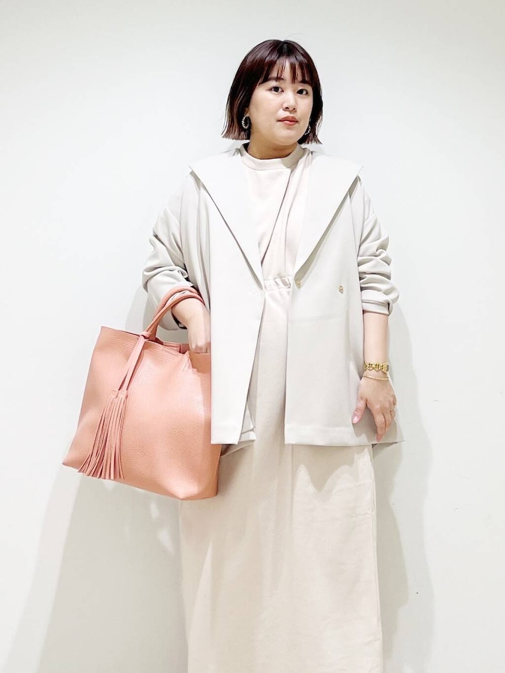 ピンク系のトートバッグ、ベージュ系のその他アウター、ベージュ系のワンピースを着用したレディースの春コーディネートの3枚目の写真