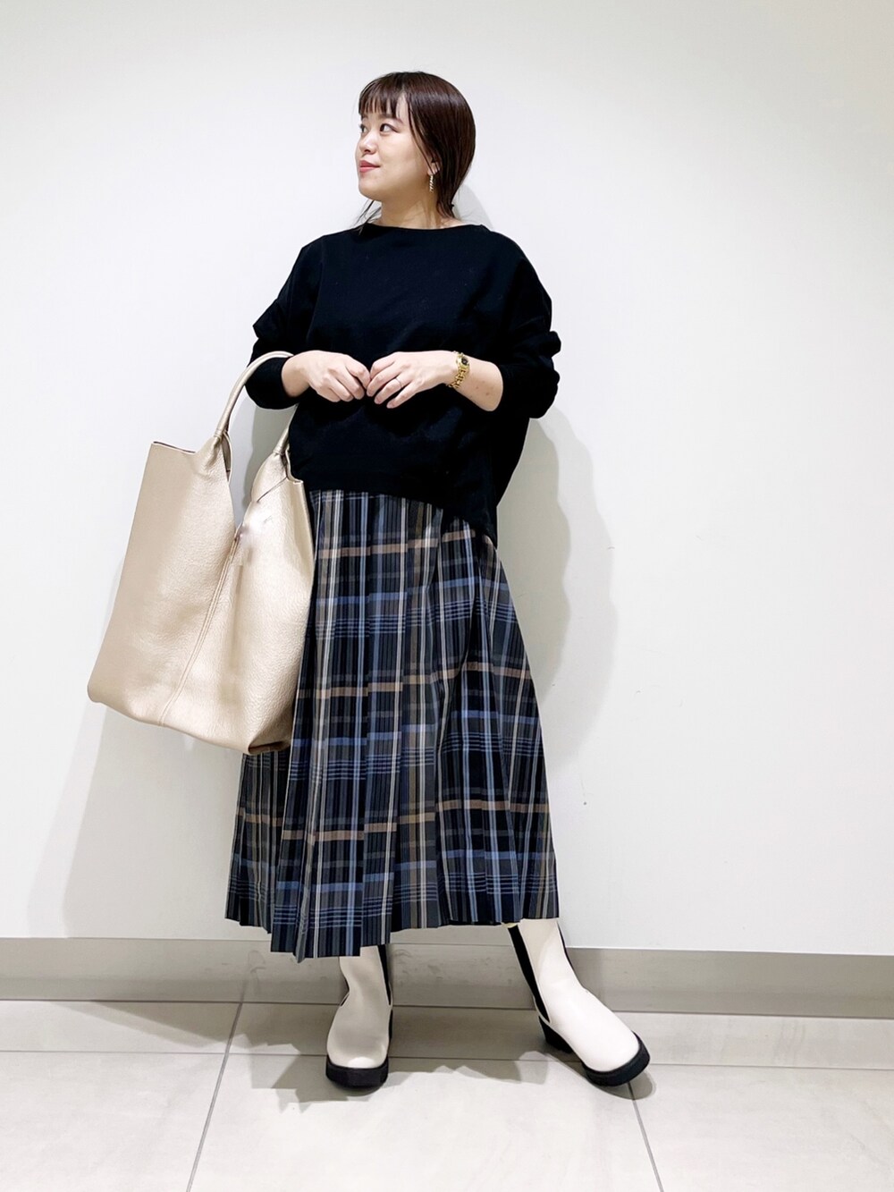 ブラック系のTシャツ/カットソー、ゴールド系のトートバッグ、ホワイト系のブーツを着用したレディースの秋コーディネートの8枚目の写真