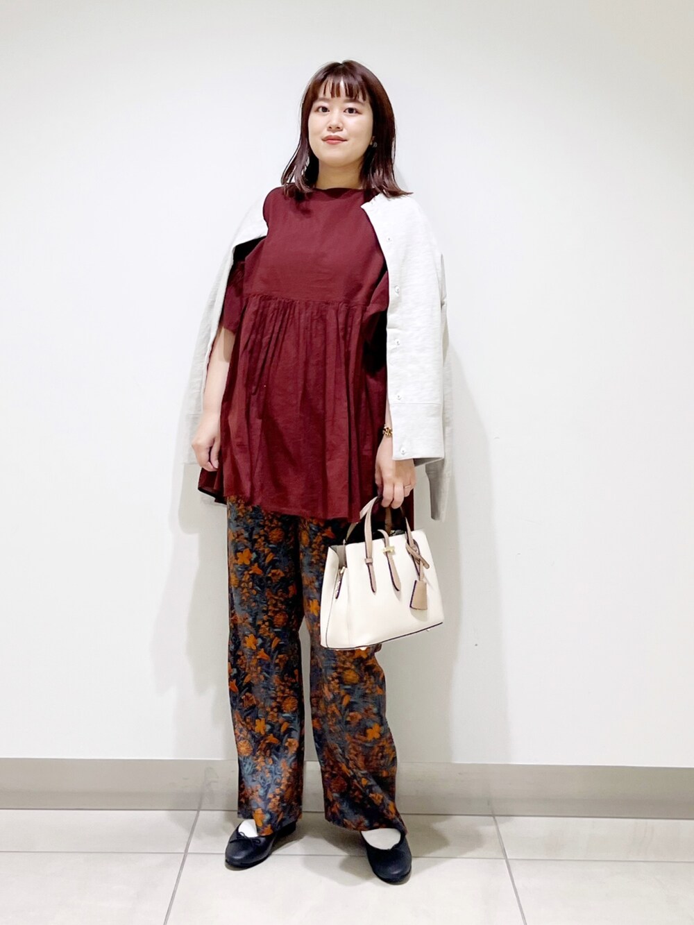 オレンジ系のその他パンツ、レッド系のシャツ/ブラウス、グレー系のカーディガン/ボレロを着用したレディースの秋コーディネートの10枚目の写真