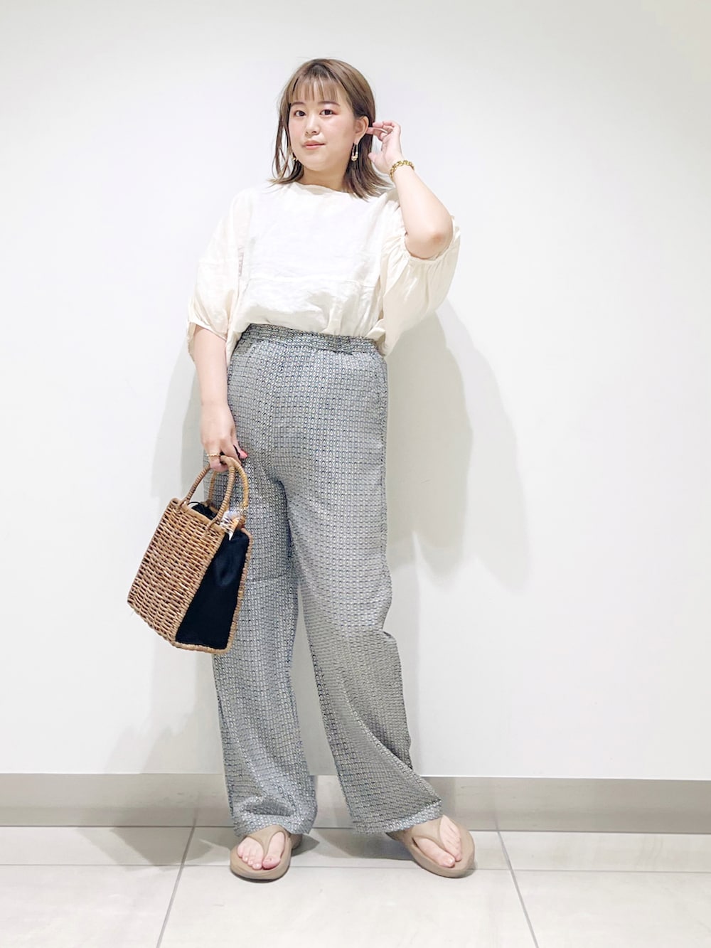 ブラック系のハンドバッグ、グリーン系のその他パンツ、ベージュ系のシャツ/ブラウスを着用したレディースの夏コーディネートの2枚目の写真