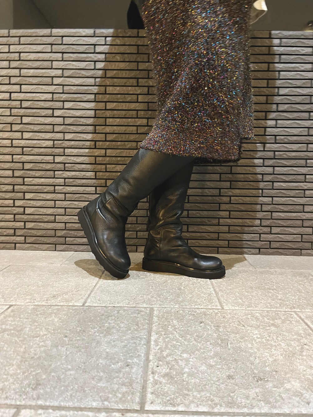 ブラック系のスカート、ブラック系のデニムジャケット、ホワイト系のTシャツ/カットソーを着用したレディースの秋コーディネートの3枚目の写真