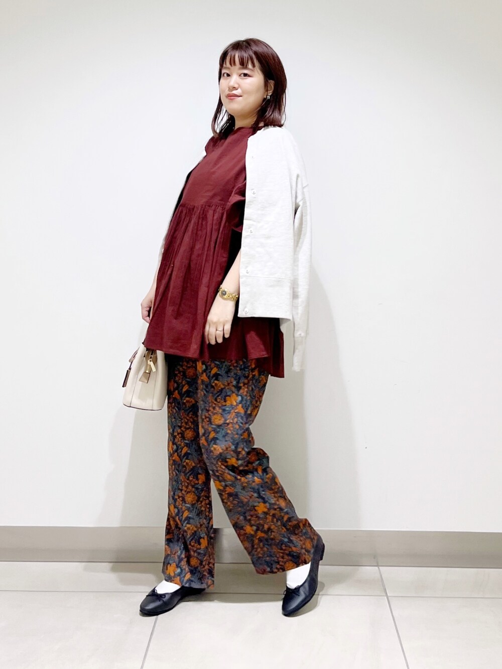 オレンジ系のその他パンツ、レッド系のシャツ/ブラウス、グレー系のカーディガン/ボレロを着用したレディースの秋コーディネートの8枚目の写真