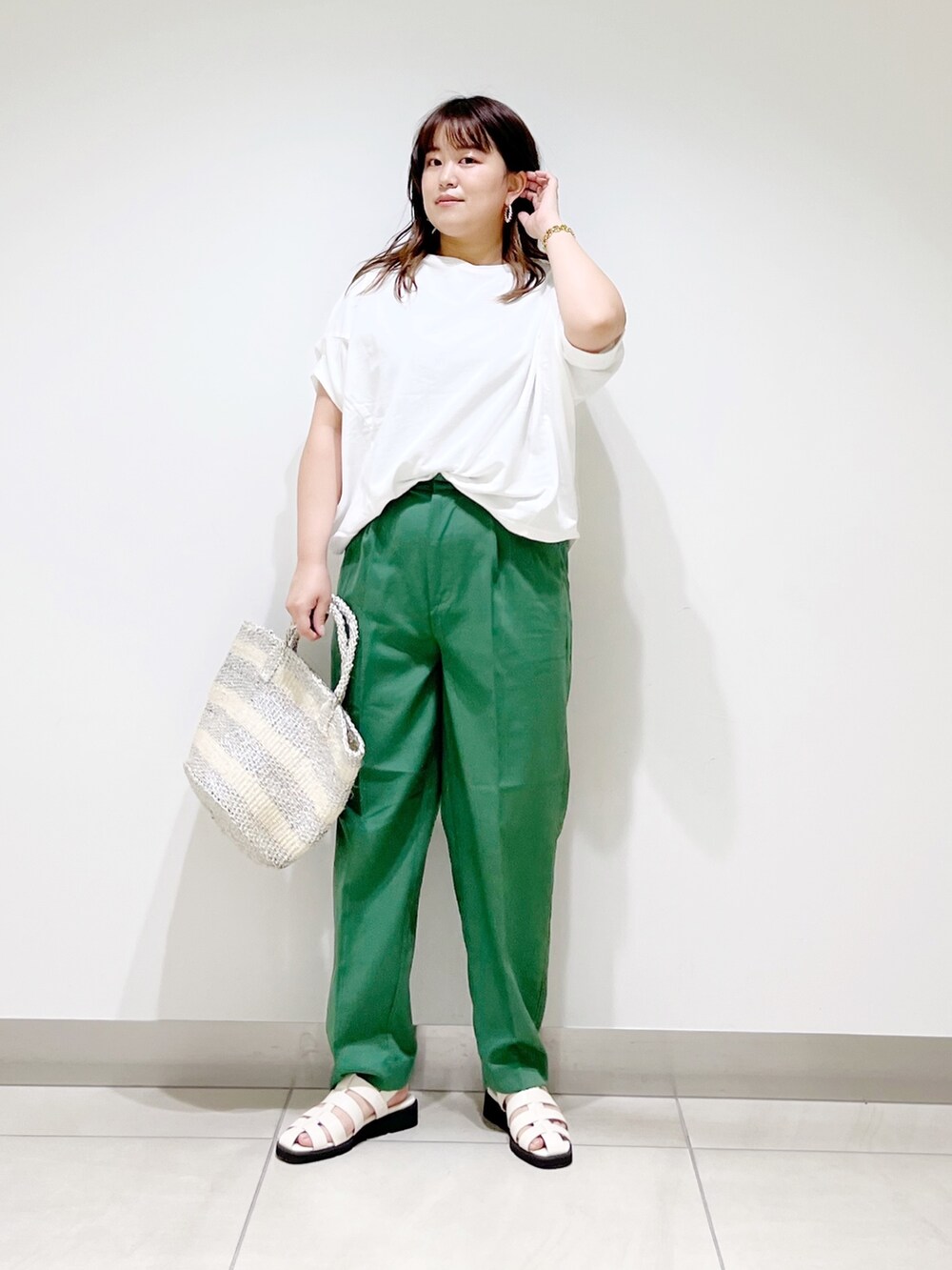 グリーン系のその他パンツ、ホワイト系のTシャツ/カットソー、ホワイト系のハンドバッグを着用したレディースの春コーディネートの4枚目の写真
