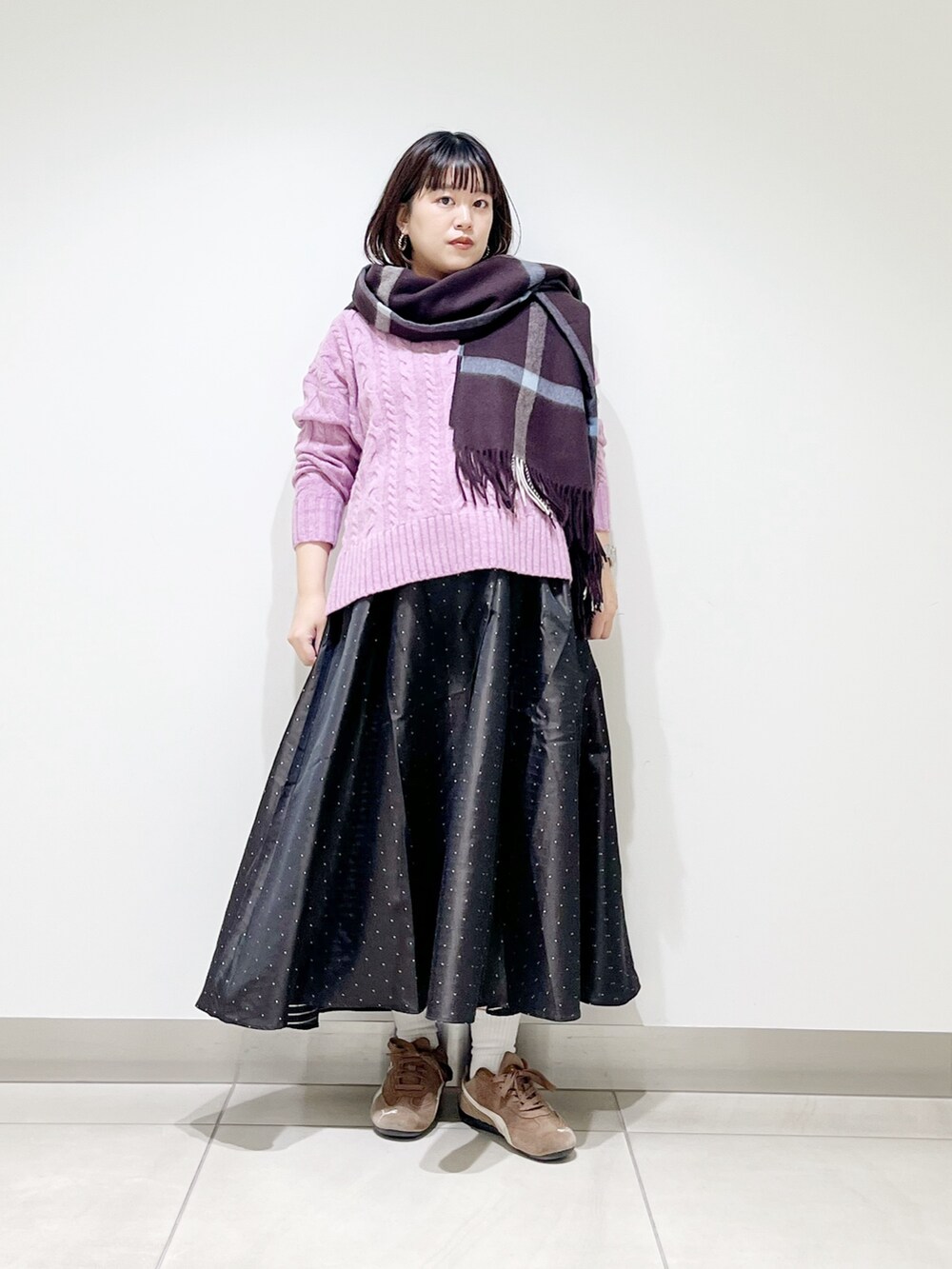 パープル系のニット/セーター、ブルー系のスカート、ブラック系のスニーカーを着用したレディースの秋コーディネートの9枚目の写真