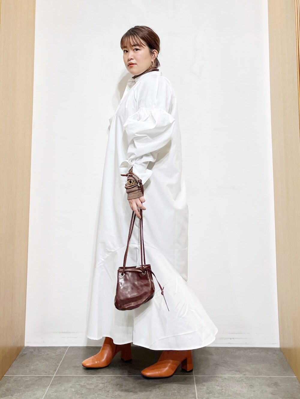 ホワイト系のワンピース、ブラウン系のハンドバッグ、ブラウン系のTシャツ/カットソーを着用したレディースの秋コーディネートの2枚目の写真