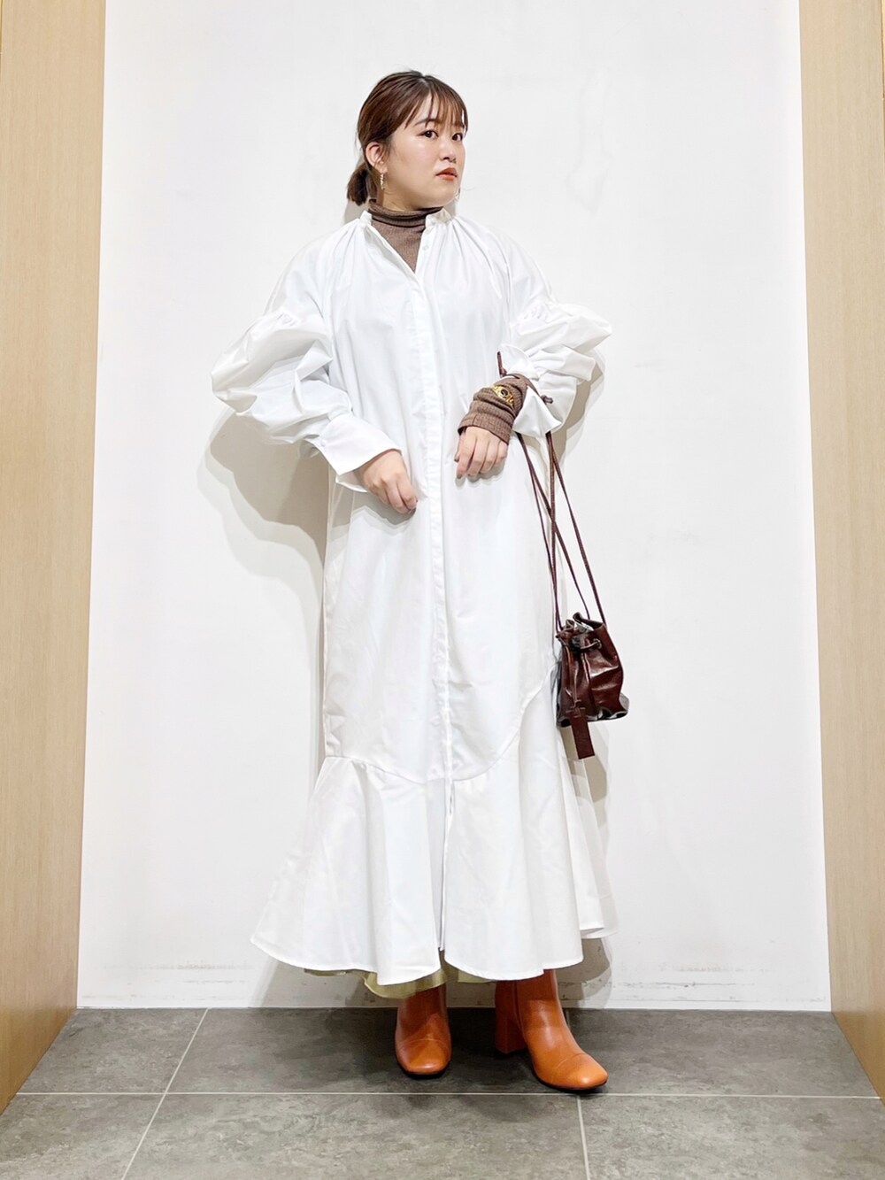 ホワイト系のワンピース、ブラウン系のハンドバッグ、ブラウン系のTシャツ/カットソーを着用したレディースの秋コーディネートの5枚目の写真