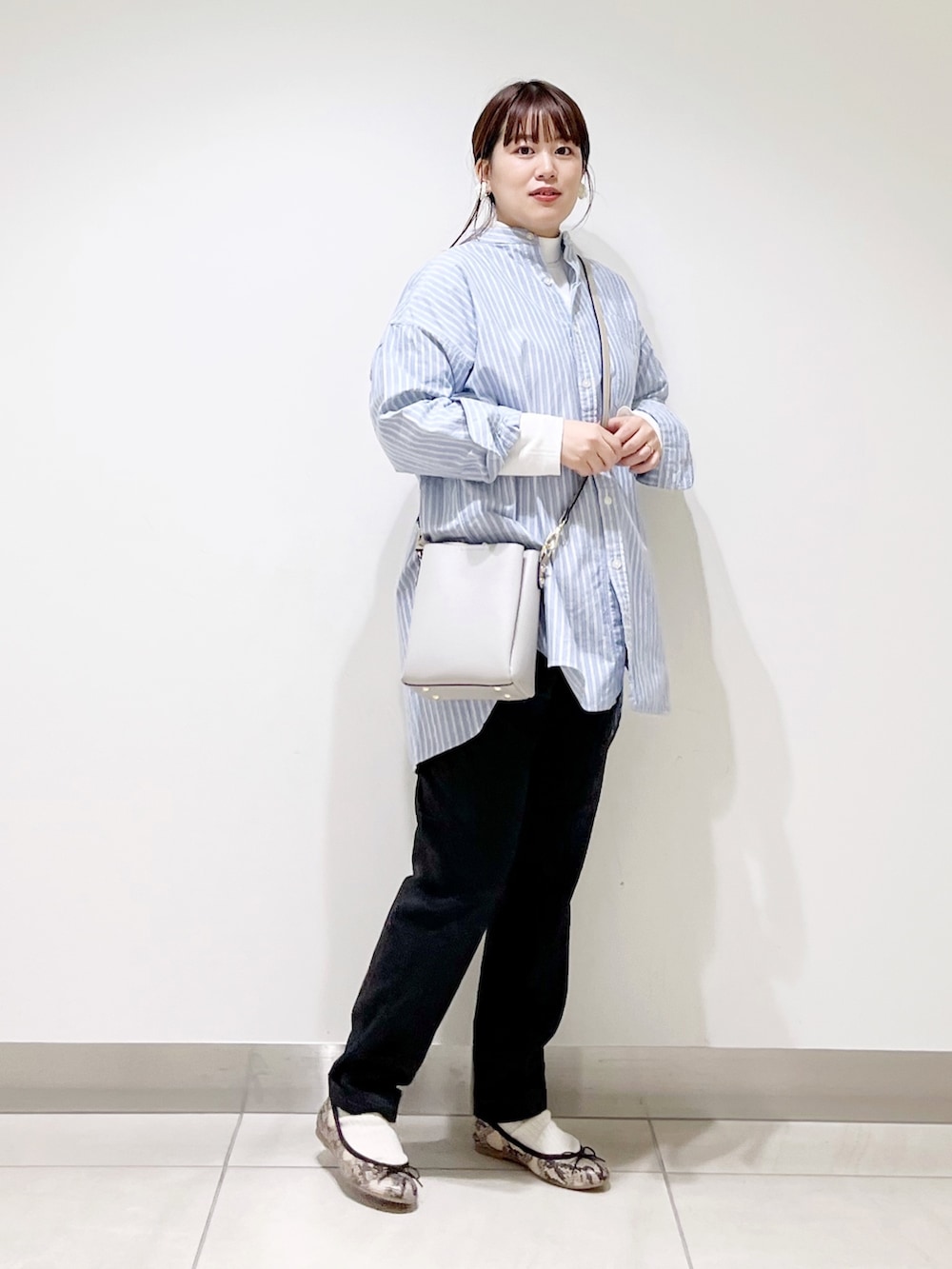 ホワイト系のTシャツ/カットソー、ブルー系のシャツ/ブラウス、グレー系のショルダーバッグを着用したレディースの秋コーディネートの3枚目の写真