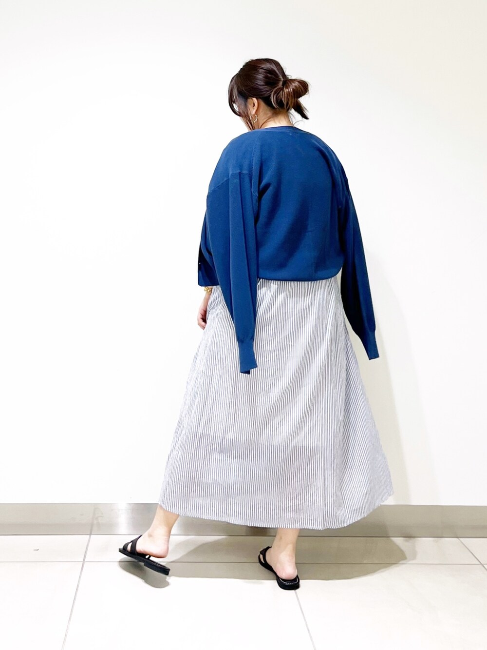 ブルー系のワンピース、ブルー系のニット/セーター、ブラック系のサンダルを着用したレディースの春コーディネートの7枚目の写真