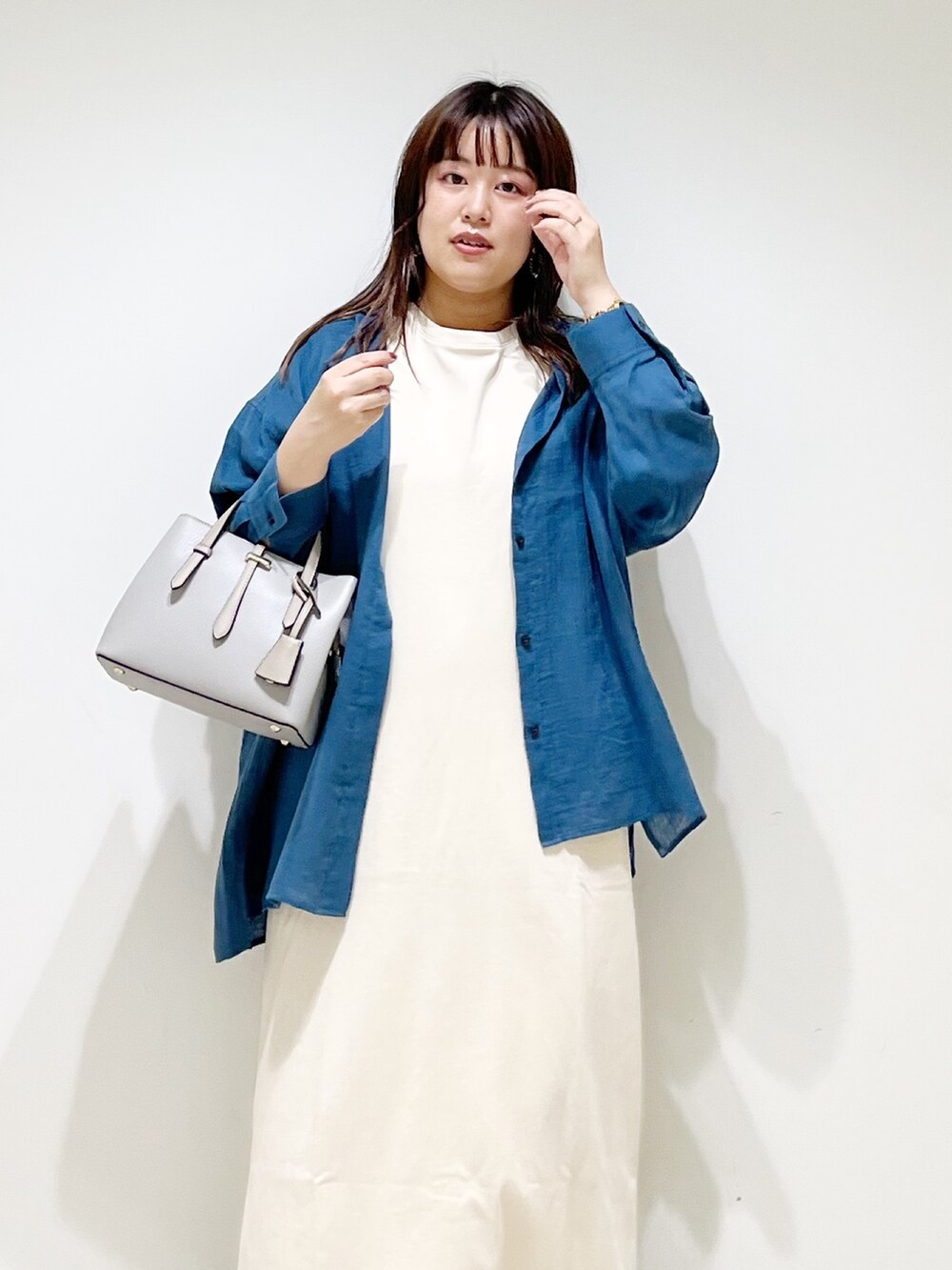 ブルー系のシャツ/ブラウス、ベージュ系のワンピース、グレー系のトートバッグを着用したレディースの夏コーディネートの4枚目の写真