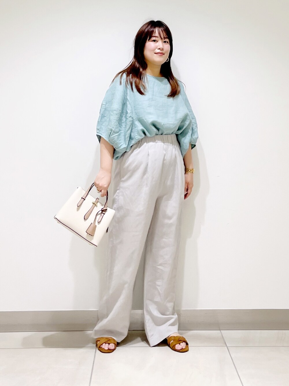 グリーン系のシャツ/ブラウス、ベージュ系のその他パンツ、ホワイト系のトートバッグを着用したレディースの夏コーディネートの3枚目の写真