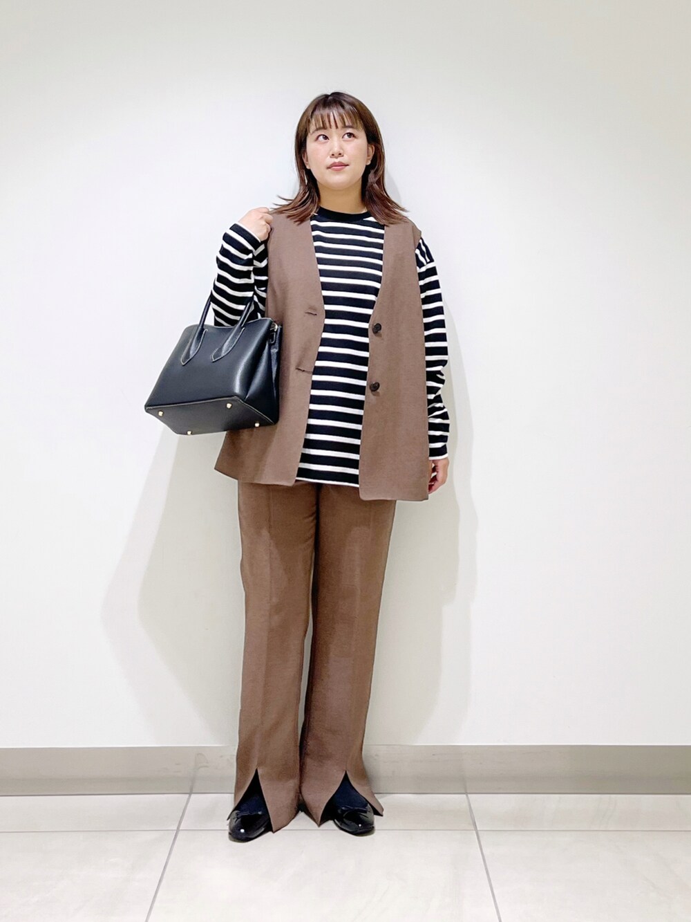 ブラウン系のベスト、ブラウン系のその他パンツ、ブラック系のTシャツ/カットソーを着用したレディースの夏コーディネートの5枚目の写真