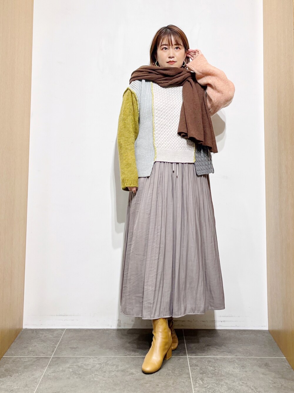 イエロー系のニット/セーター、グレー系のその他パンツ、イエロー系のブーツを着用したレディースの秋コーディネートの5枚目の写真