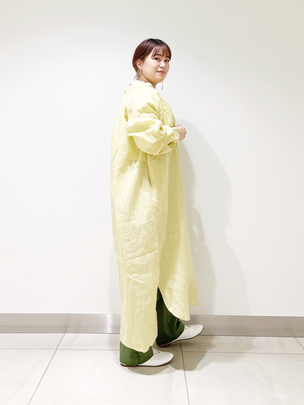 イエロー系のワンピース、ホワイト系のTシャツ/カットソー、グリーン系のその他パンツを着用したレディースの冬コーディネートの2枚目の写真