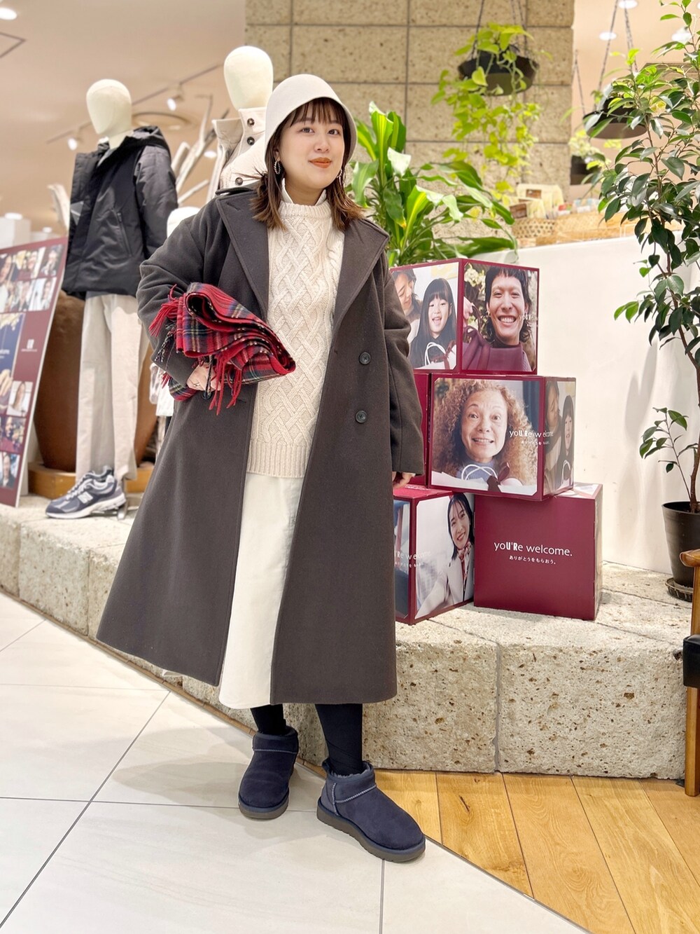 グレー系のチェスターコート、ホワイト系のワンピース、ベージュ系のニット/セーターを着用したレディースの冬コーディネートの3枚目の写真