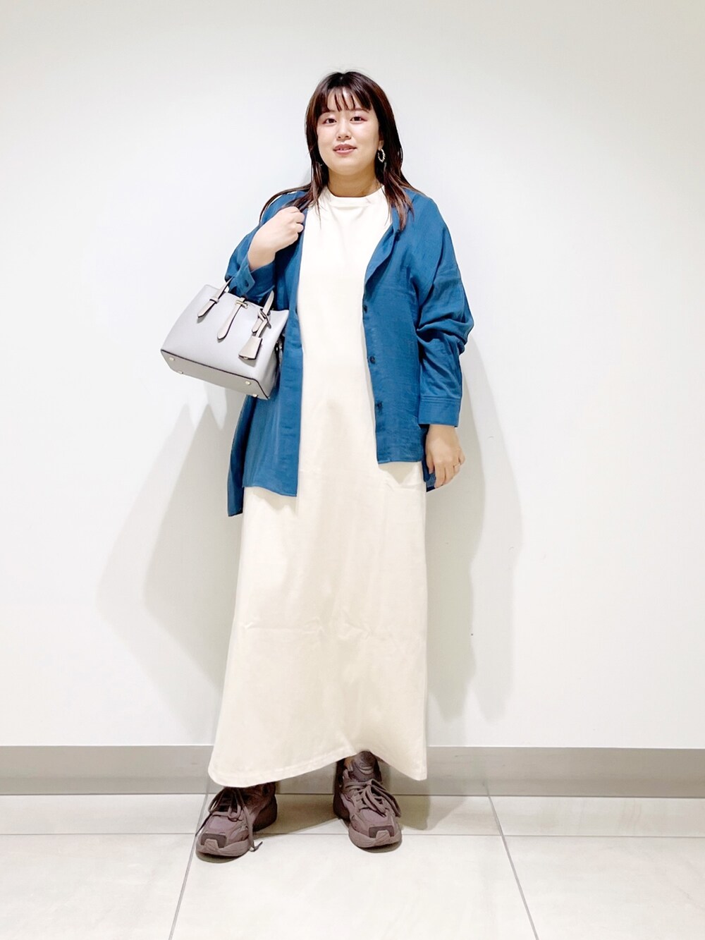 ブルー系のシャツ/ブラウス、ベージュ系のワンピース、グレー系のトートバッグを着用したレディースの夏コーディネートの2枚目の写真