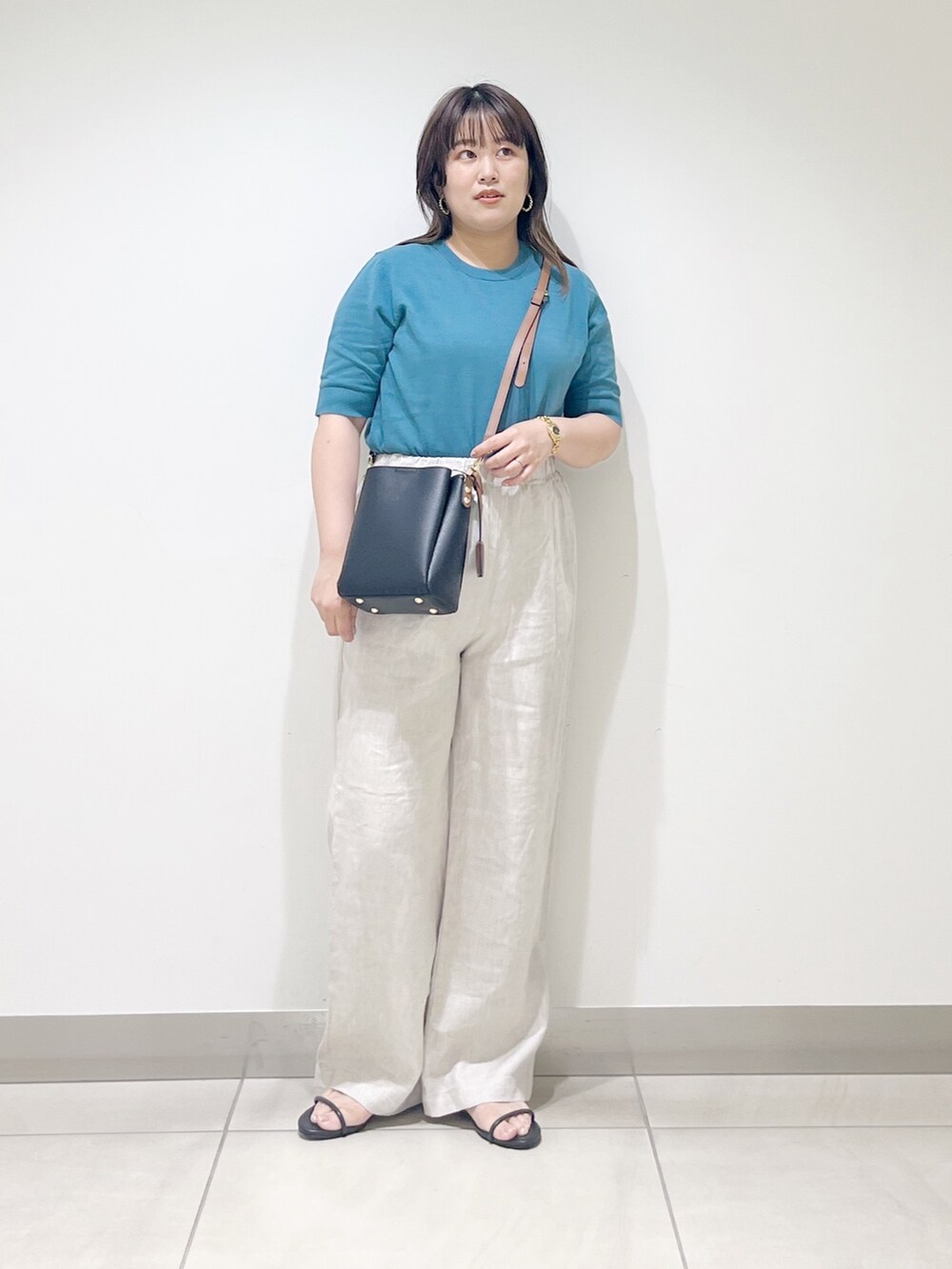 ブルー系のニット/セーター、ベージュ系のその他パンツ、ブラック系のショルダーバッグを着用したレディースの春コーディネートの6枚目の写真