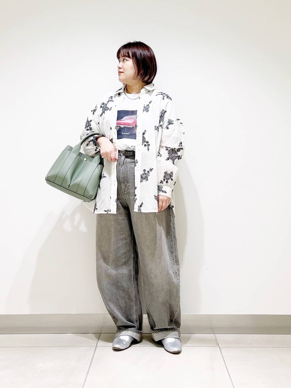 グリーン系のデニムパンツ、グリーン系のトートバッグ、シルバー系のパンプスを着用したレディースの春コーディネートの2枚目の写真